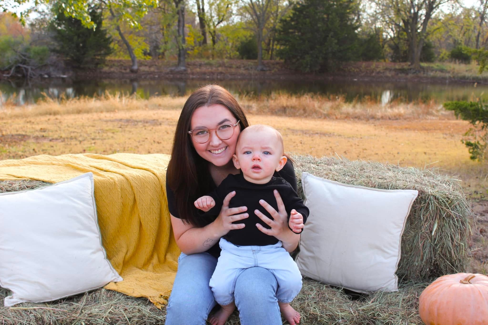 Mom and baby on the fall mini set with hay bales and pillows